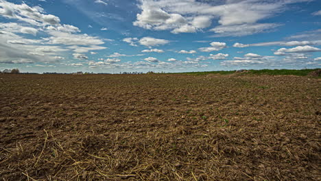 Farmland-terrain-with-clouds-moving-in-blue-sky