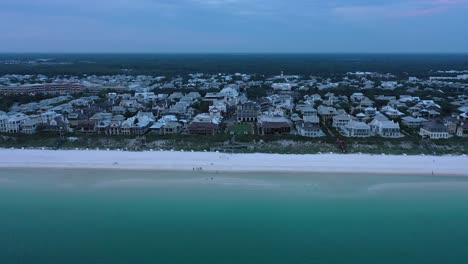 Drone-view-flying-over-the-Gulf-of-Mexico-and-lowering-down-towards-the-beach-in-Rosemary-Florida-during-golden-hour-sunset