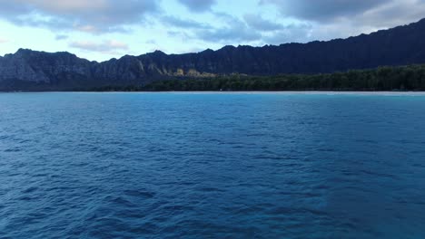 An-offshore-view-of-the-ocean,-forest,-and-mountains-of-OAHU