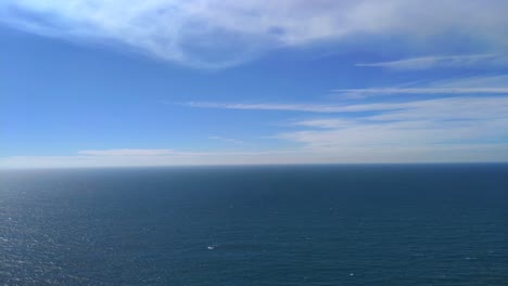 Immensity-of-the-calm-sea-with-residual-clouds-to-the-horizon-on-a-sunny-summer-day,-panoramic-shot-turning-right,-Cíes-Islands,-Pontevedra,-Galicia,-Spain