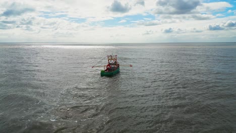 Fishing-boat,-trawler-off-the-East-Coast-of-the-UK,-sailing-into-the-sun-on-a-choppy-sea