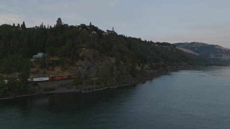 Drone-aerial-of-a-train-traveling-along-the-Columbia-River-in-southern-Washington
