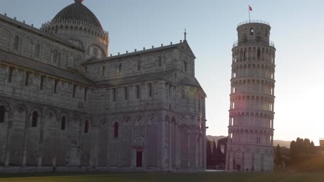 Total-establish-shot-of-leaning-tower-of-pisa-with-dolly-movement-in-the-morning,-golden-hour,-tuscany-with-sun-flare-and-blue-clear-sky-made-with-a-fi