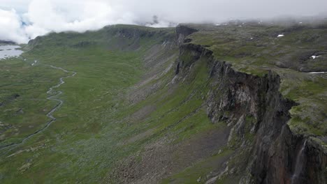 Cinematic-aerial-drone-shot-of-mountain-cliffs-revealing-the-Skytjedalen-valley-in-Hardangervidda-National-Park