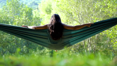 Mixed-race-long-black-hair-woman-relaxing-on-hammock-in-natural-unpolluted-environment