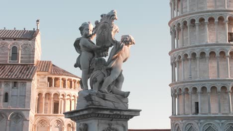 Leaning-tower-of-pisa-with-statue-in-the-foreground,-dolly-movement-with-gimbal