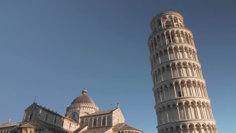 Still-shot-with-one-bird-crossing-to-the-right-in-front-of-the-leaning-tower-of-pisa-in-tuscany-italy-during-the-morning-and-golden-hour