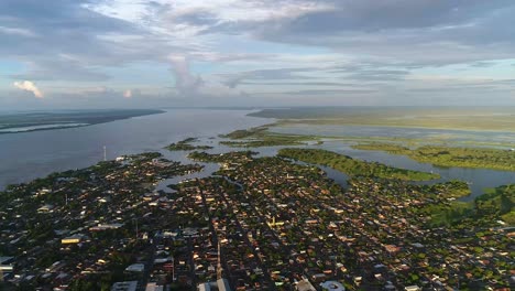 Drone-take-aerial-view-of-the-Parintins-city-from-a-great-height-on-a-cloudy-day-in-Amazonas,-Brazil