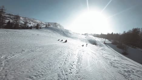 FPV-Aufnahme-Eines-Skifahrers,-Der-Langsamer-Wird-Und-Dann-Anderen-Skifahrern-Den-Hang-Hinunter-Folgt