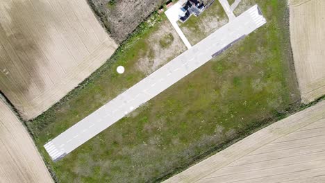 Cenital-aerial-shot-of-small-runway-surrounded-by-grass