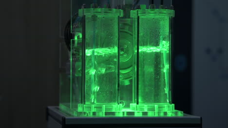 Wasserstoffgasblasen-In-Rohren-Mit-Wasser-In-Einem-Elektrolyseur-Demonstrator,-Grünes-Licht,-Zeitlupe-1
