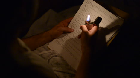 A-soldier-reading-a-letter-at-night-with-a-zippo-lighter