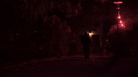 People-walking-away-under-red-dim-lights