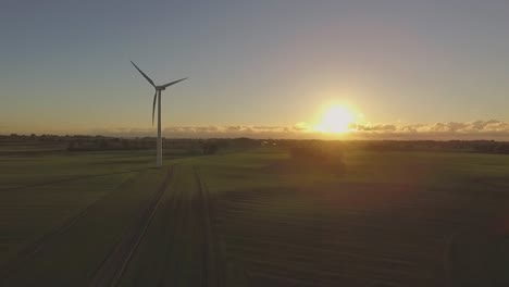 Shot-of-a-wind-turbine-during-sunset,-spinning-and-creating-renewable-energy
