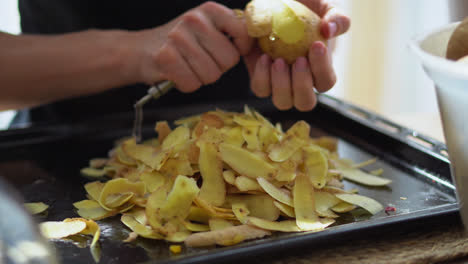 A-Person-Peeling-Potatoes-In-The-Kitchen