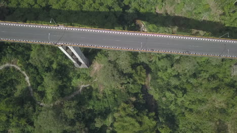 Tilt-shift-aerial-looks-down-onto-Jembatan-Tukad-Bangkung-bridge,-Bali