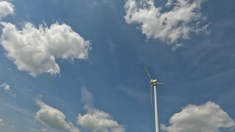 Low-angle-shot-of-a-wind-turbine,-spinning-and-creating-renewable-energy,-4K