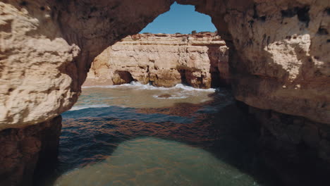 Drone-pull-back-through-a-natural-archway-made-out-of-rock