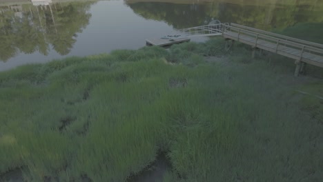 Disparo-De-Drones-Hacia-El-Muelle-Con-Kayak-Y-Río,-New-Hampshire-Waterside