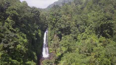 Aerial-approaches-lush-green-jungle-waterfall-in-North-Bali-mountains