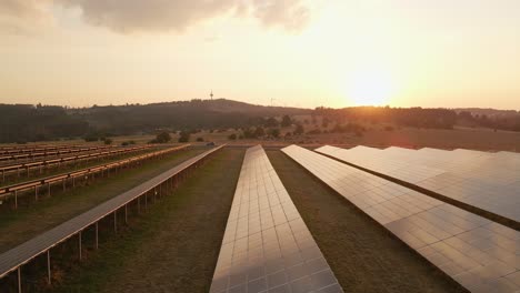 Wide-angle-establishing-shot-of-a-beautiful-sunset-over-photovoltaic-panels-of-a-solar-farm-in-rural-Germany