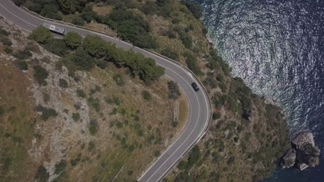 Aerial:-Amalfi-highway-curves-on-cliff-top-promontory,-sea-far-below