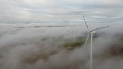 Filmaufnahme-Mehrerer-Windkraftanlagen-Im-Nebel,-Die-In-Den-Niederlanden-Erneuerbare-Energie-Erzeugen