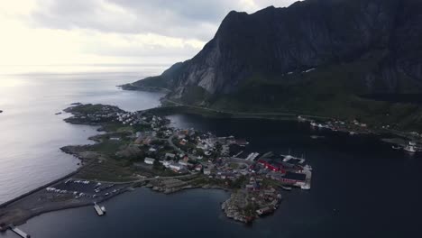 Aerial-view-of-Reine,-Norway---tiny-and-incredibly-picturesque-fishing-village,-Island-of-Moskenesoya-on-the-Lofoten-archipelago-and-Reinebringen-mountain-coast-at-sunset