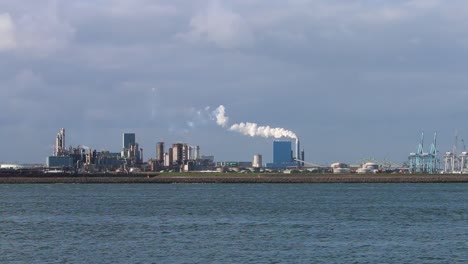 Looking-across-the-water-from-the-Hook-of-Holland-towards-factories,-chimney-and-docks-etc