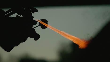 Igniting-a-flame-cutter-in-slow-motion,-silhouette