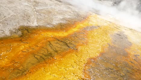 Dutch-tilt-closeup-of-trickling-water-from-vibrant-yellow-orange-geyser-at-Yellowstone-National-Park