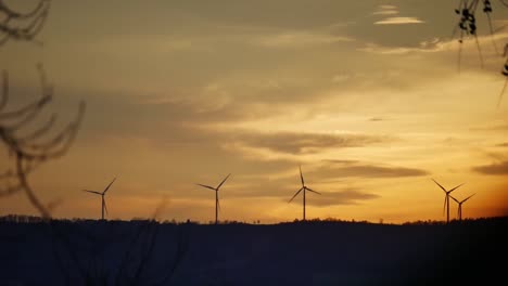 -Shot-of-a-wind-turbines-during-sunset,-rotating-and-creating-renewable-energy
