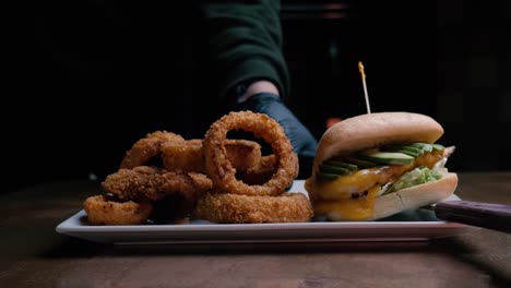 A-chicken-burger-and-onion-rings-are-pushed-into-the-frame