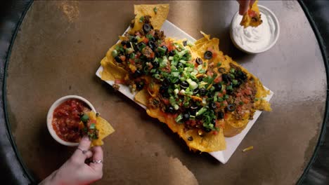 A-group-of-hands-sharing-a-plate-of-nachos