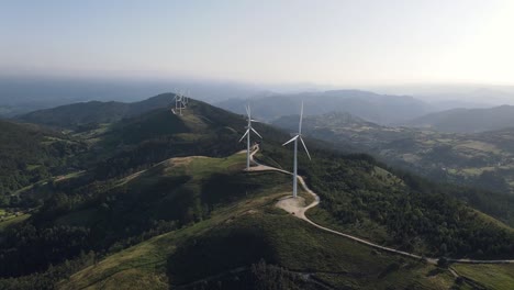 Shot-of-a-wind-turbines-on-top-of-a-hill,-spinning-and-creating-renewable-energy