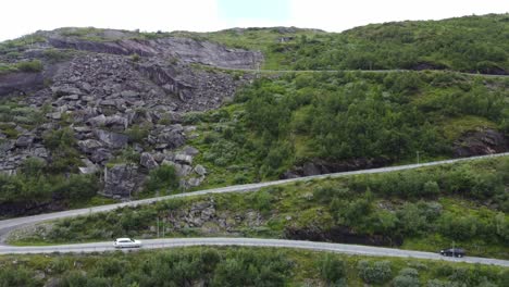 Hairpin-turns-and-winding-roads-with-summer-tourist-traffic-at-Halsabakkane-hills-Vikafjell-mountain-Norway---Ascending-aerial