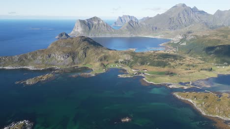 Flying-over-two-people-standing-at-the-edge-of-Offersoykammen-mountain-in-Lofoten-Norway-with-panoramic-view-over-the-ocean-and-the-surrounding-mountains