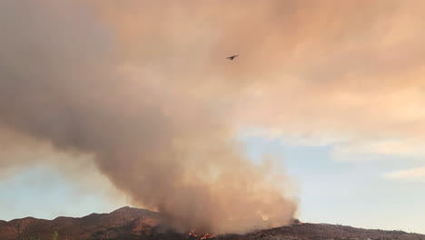Un-Avión-De-Extinción-De-Incendios-Vuela-Lejos-De-La-Columna-De-Humo-En-Los-Incendios-Forestales-Masivos-Cerca-De-Hemet-En-El-Condado-Ribereño-De-California