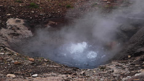 Wide-angle-view-of-the-Litli-Geysir-bubbling,-steam-coming-off-the-hot-water