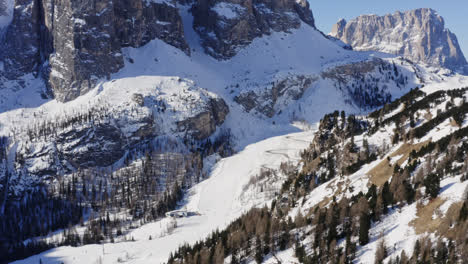 Flying-On-Winter-Ski-Slopes-Of-The-Dolomites-With-Towering-Mountain-Ranges-In-Passua,-Italy