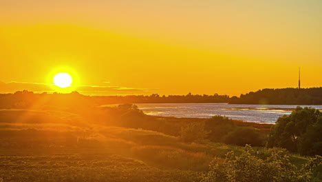 Goldener-Stundensonnenuntergang-über-See-Und-Ländlicher-Landschaft-Mit-Schöner-Silhouette-Im-Hintergrund