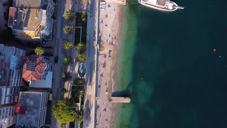 AERIAL-Top-Down-Fly-By-over-the-Promenade-in-Sarande,-Albania-by-the-Beach