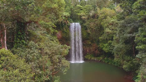 Aerial-dolly-in-shot-getting-close-to-a-waterfall-in-North-Queensland,-Milla-Milla-Falls