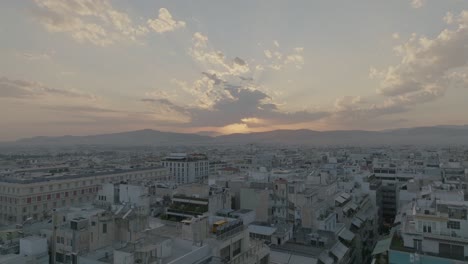 Aéreo---Vuelo-Bajo-Sobre-Edificios-En-Atenas,-Grecia-Al-Atardecer