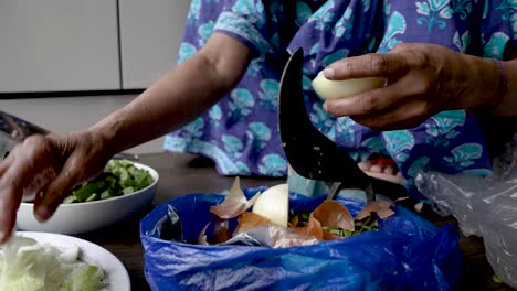 Hands-Of-Elderly-Muslim-Women-Sat-On-Floor-Using-Pahsul-or-Boti-To-Slice-Onions