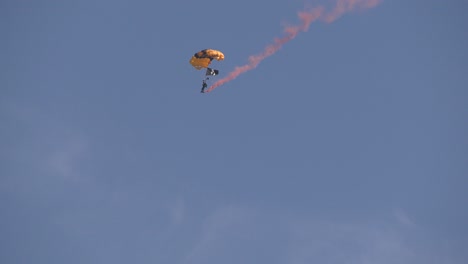 Parachuters-with-smoke-trail-landing