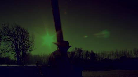 Cowboy's-Silhouette-in-the-Winter-Landscape-during-Polar-Green-Night