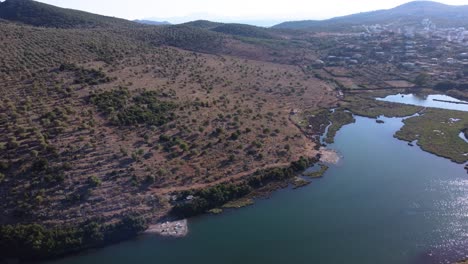 AERIAL-Side-Panning-Shot-over-Lake-Butrint-with-Ksamil-in-the-Background,-Albania