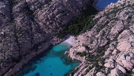 Aerial-View-Of-Secluded-Beach-With-Turquoise-Waters-Surrounded-By-Granite-Rocks-At-Cala-Coticcio
