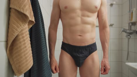 Mann-überprüft-Seinen-Genitalbereich,-Indem-Er-In-Einem-Badezimmer-Einen-Blick-In-Seine-Unterhose-Wirft
